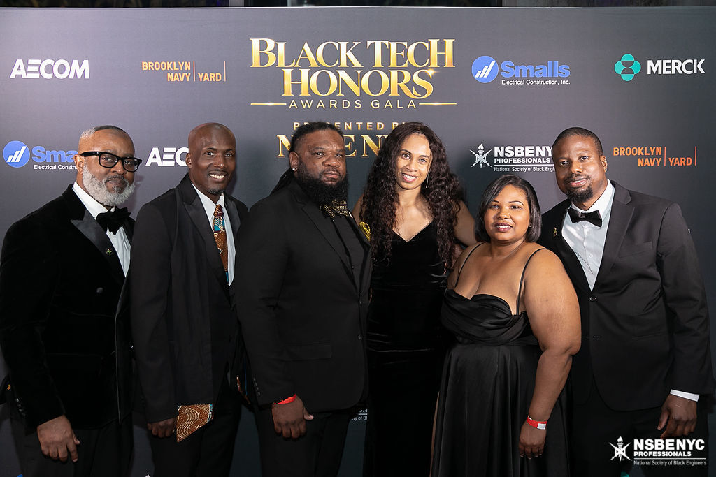 NSBE NYC members and guests in formal attire at the Black Tech Honors sponsor backdrop