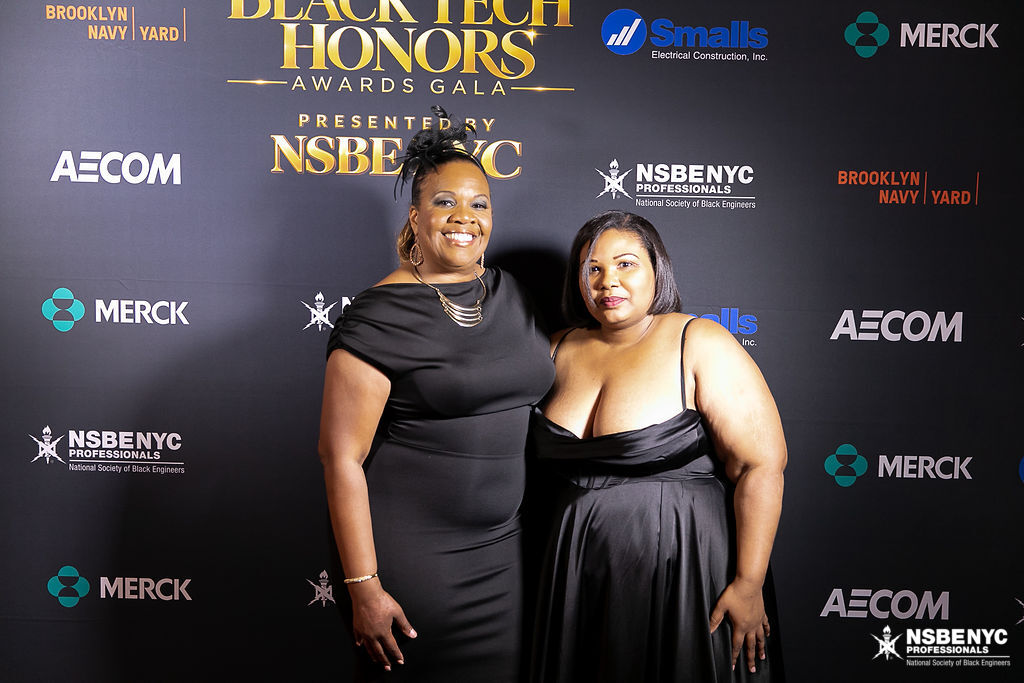 Two NSBE NYC professionals together at the Black Tech Honors sponsor backdrop